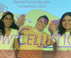 Winning team posing and smiling in front of projector 