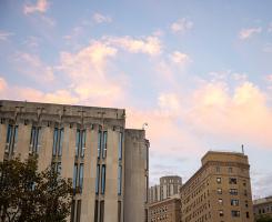 The top of Hillman Library against a blue sky and pink clouds