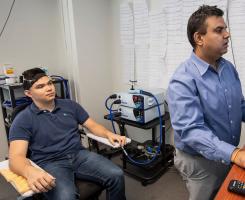 A subject and professor look at brain scans on a monitor