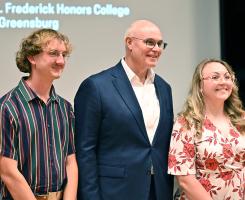 David Frederick stands with three honors students