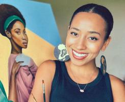 Pittsburgh artist Morgan Overton smiles beside her "We Are Not Going Back" painting.