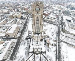 An aerial view of the Cathedral of Learning during the winter that shows its entire front facade.