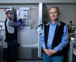 Charles Rinaldo poses for a portrait in the lab with a colleague.