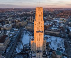 Aerial view of the Cathedral of Learning and campus at sunset during the winter.