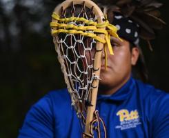 Man holding wooden lacrosse stick