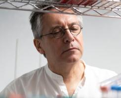 Pitt reasearcher looking at test tubes