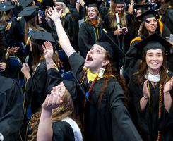 Graduates clap and cheer after the commencement ceremony.