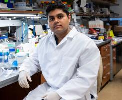 Rohit Mantena sits at a lab bench
