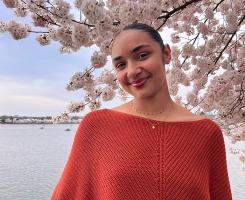 Mackenzie Evans in front of a blossoming tree