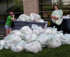 Two students posing with garbage bags