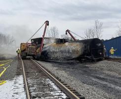 A crew removes a damaged train car from the track
