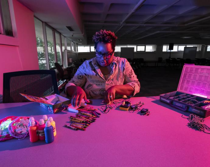 A woman builds a robot at a table