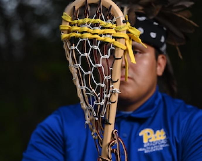 Man holding wooden lacrosse stick