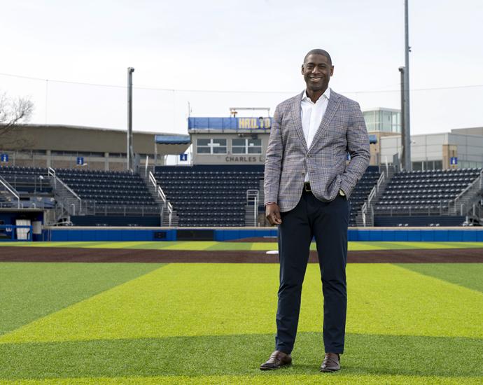 Portrait of man standing on field of baseball stadium.