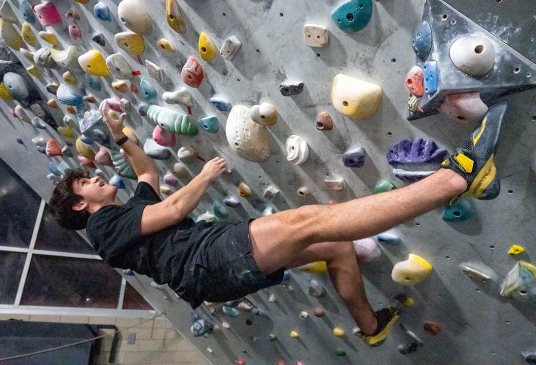 A climber scales an indoor rock wall