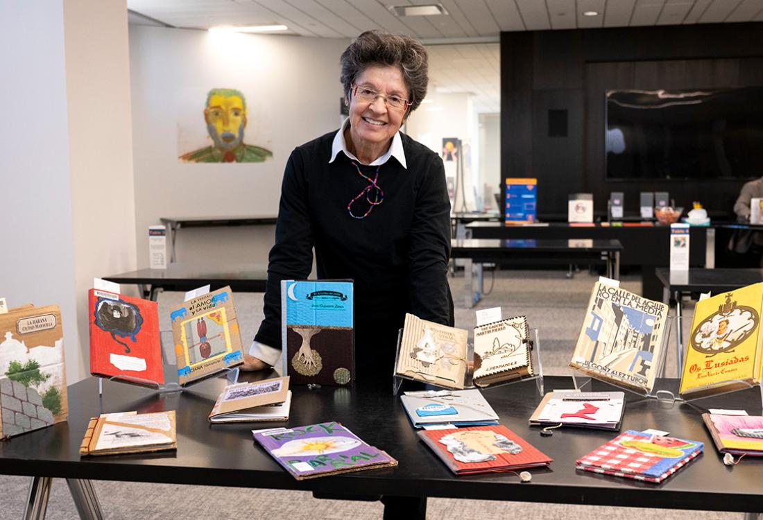 Mantilla stands behind a table of books