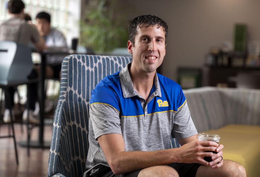 Man sitting in a chair and holding a cup of coffee