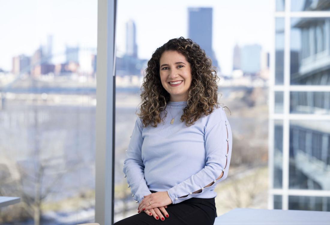 Woman sitting in front of bank of office windows