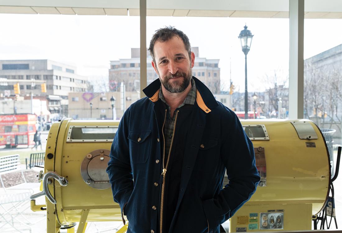 Wyle stands in front of a window in a medical facility