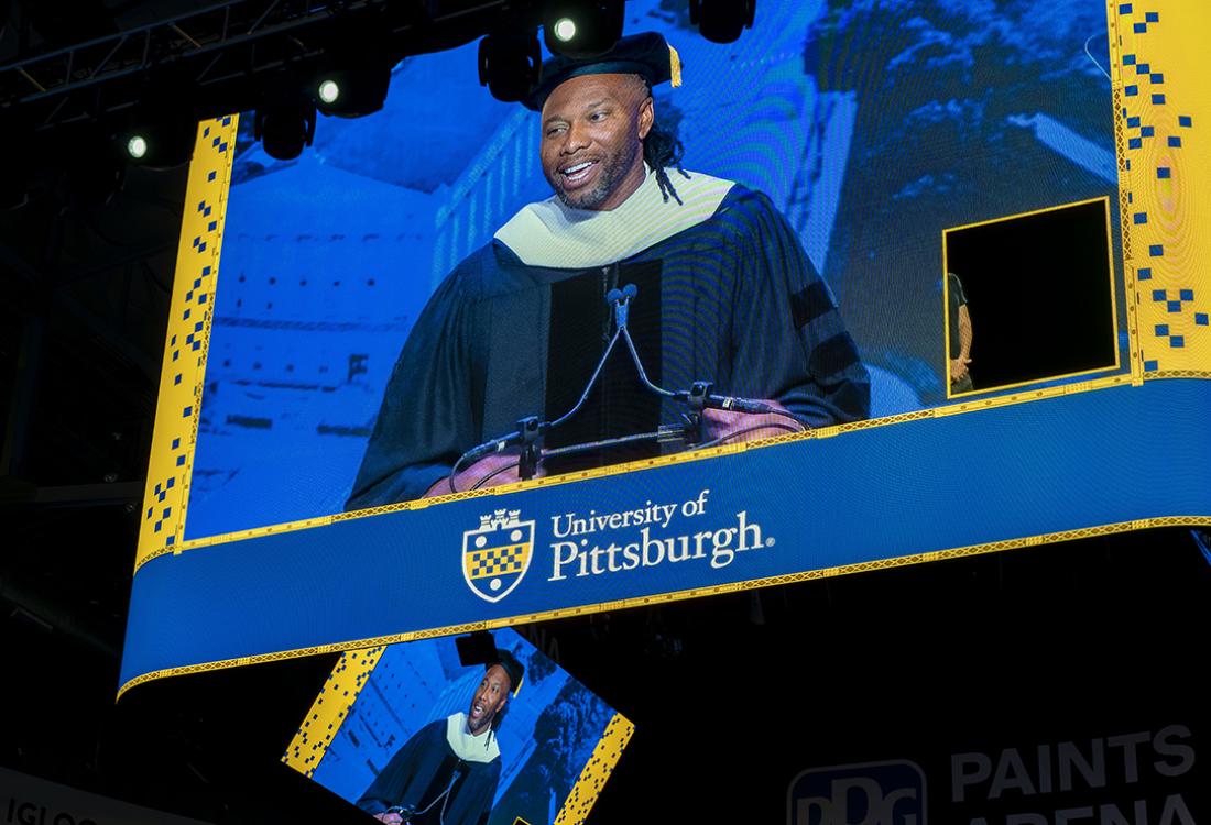 Fitzgerald speaks on stage, visible through arena video board