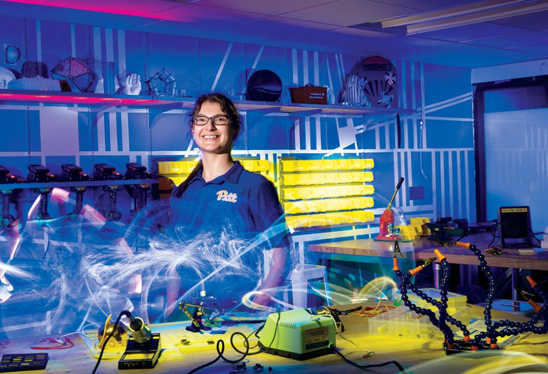 A student researcher poses for a photo in a lab space