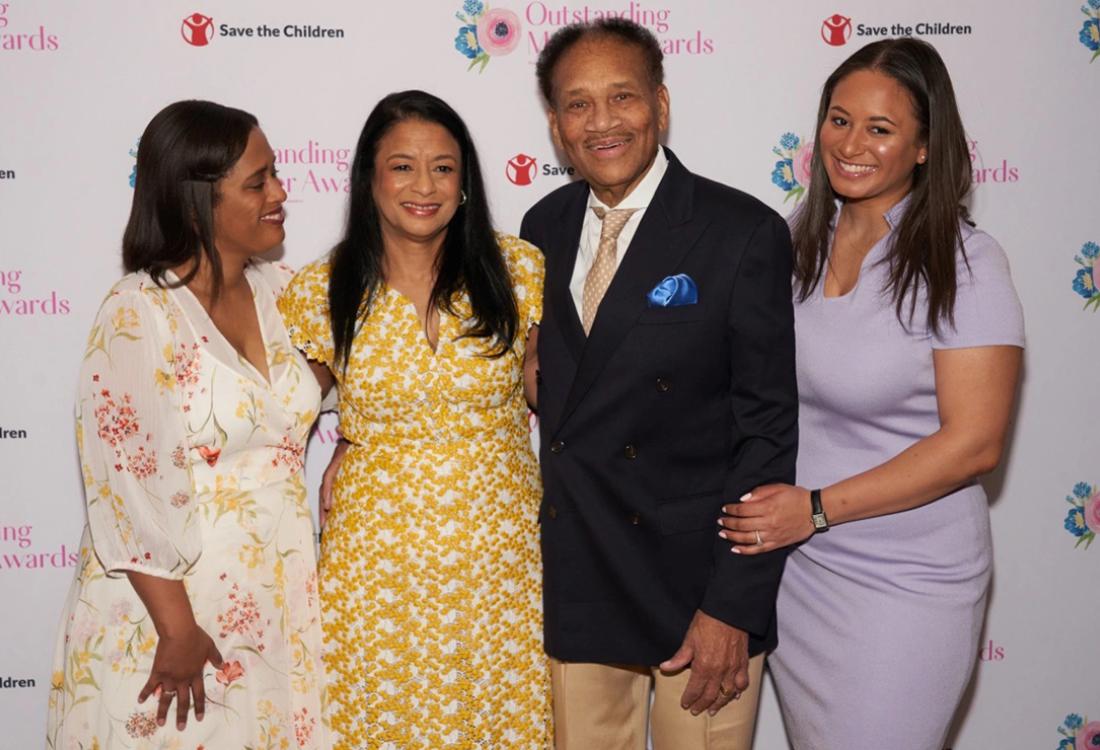 Woman, man and two daughters pose at event for a family photo