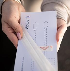 A girl holds an unused swab kit from the National Marrow Donor Program