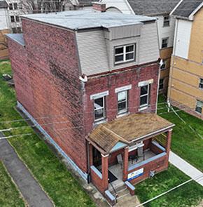 An aerial image of the outside of Pitt's Healthy Home Lab, still looking just like a prototypical three-story Pittsburgh home