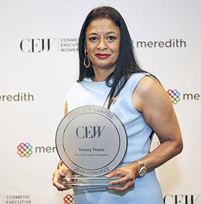Woman holds aware in front of event backdrop