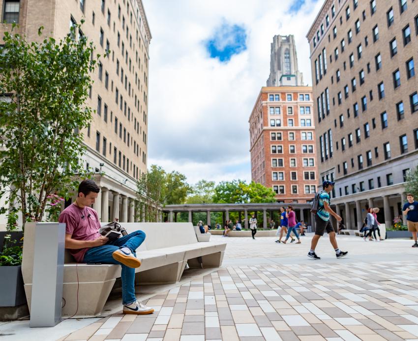 Students sitting and walking around the Schenley Quadrangle