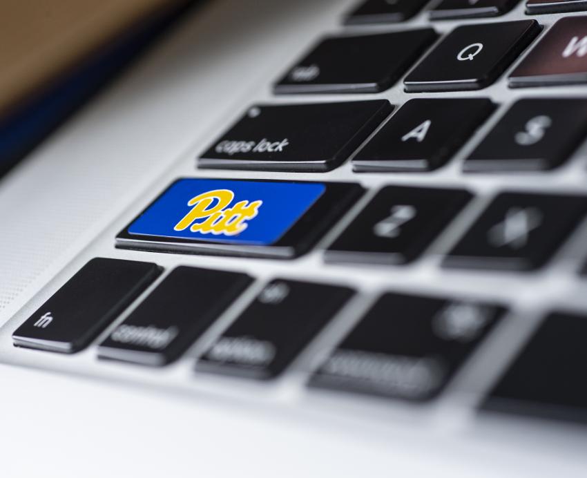 Closeup of a keyboard with one of the keys labeled "Pitt"