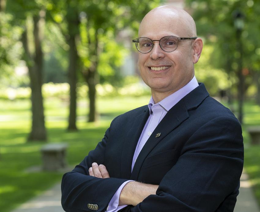 Robert K. Cunningham standing outside with arms folded, trees in background