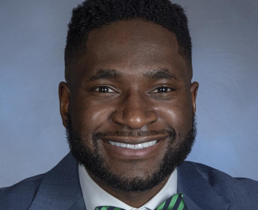 Utibe Essien in a blue suit and striped green bowtie