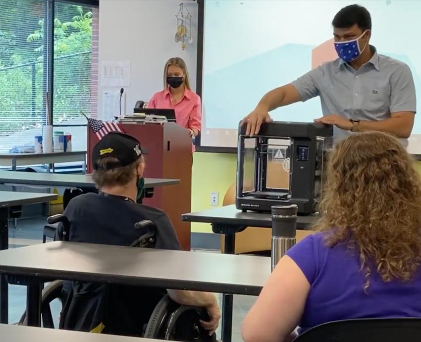 Man presenting a machine in front of a class
