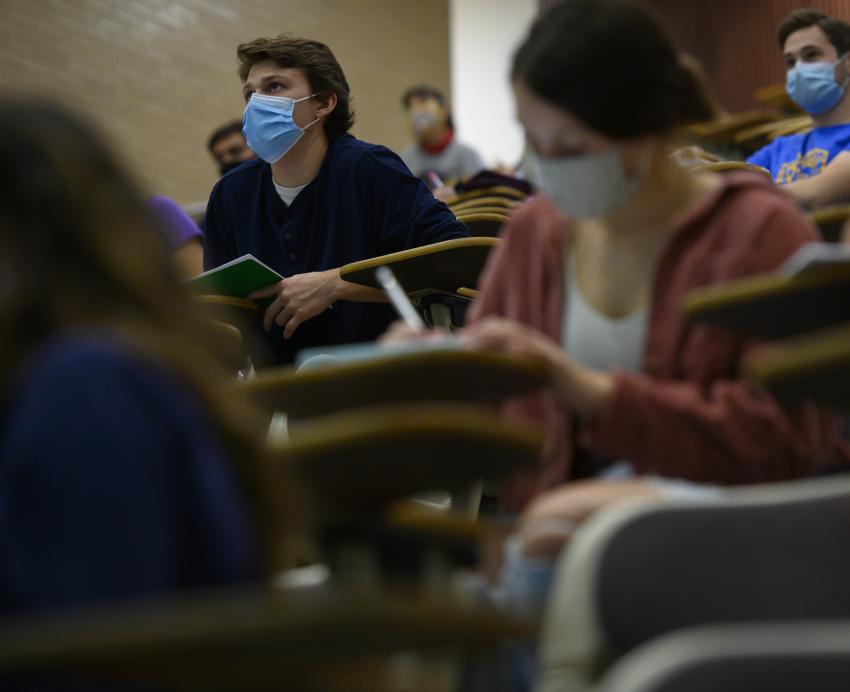 Students at desks in masks, attending a class