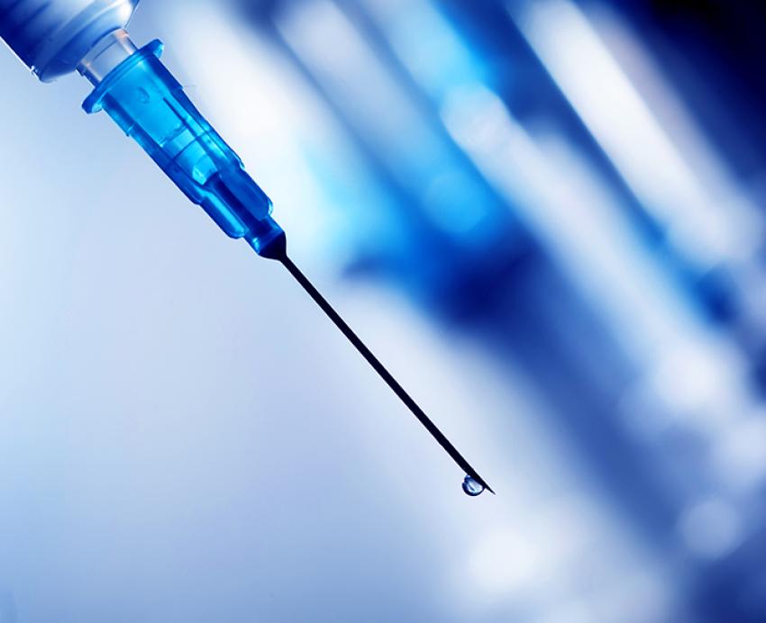 Syringe with liquid dripping out of the tip