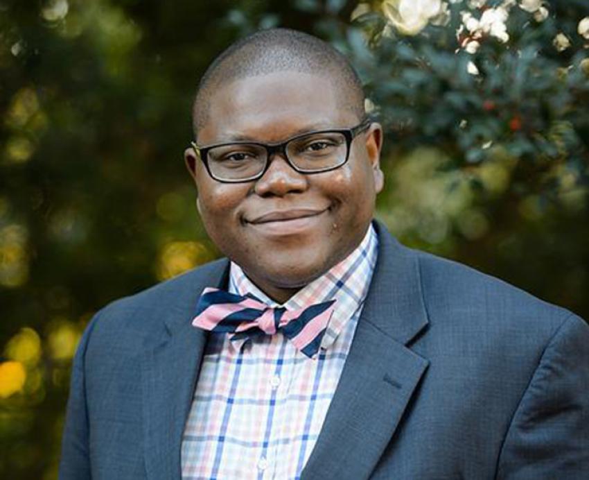 Darris Means wearing suit, smiling