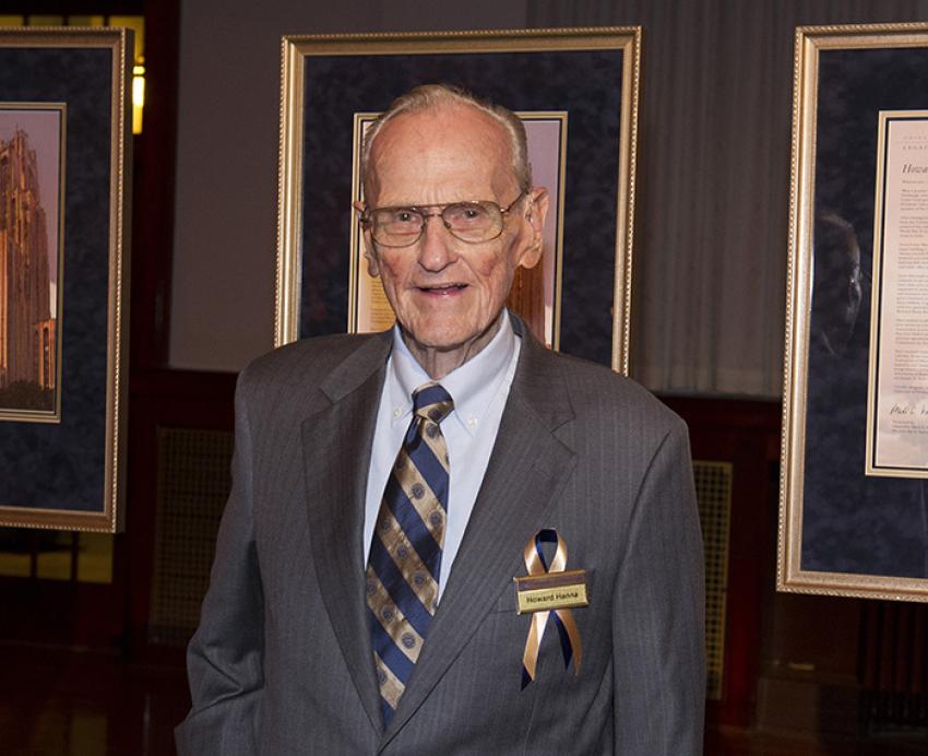 Howard Hanna wearing grey suit with blu and gold tie