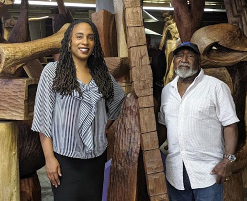 Daren Ellerbee and Thaddeus Mosley standing by wooden art piece