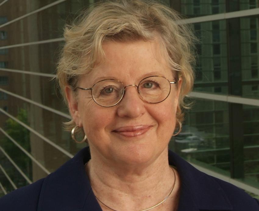 Jacqueline Dunbar-Jacob with glasses and suit, standing next to building