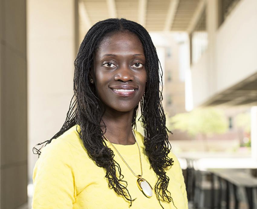 Valerie Kinloch smiling with yellow shirt and necklace