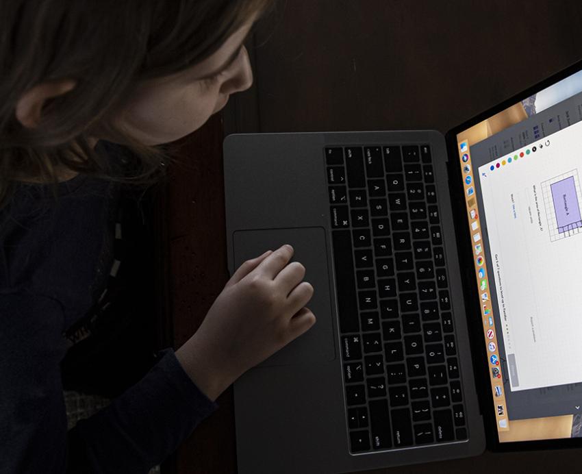 Teen using laptop at a table