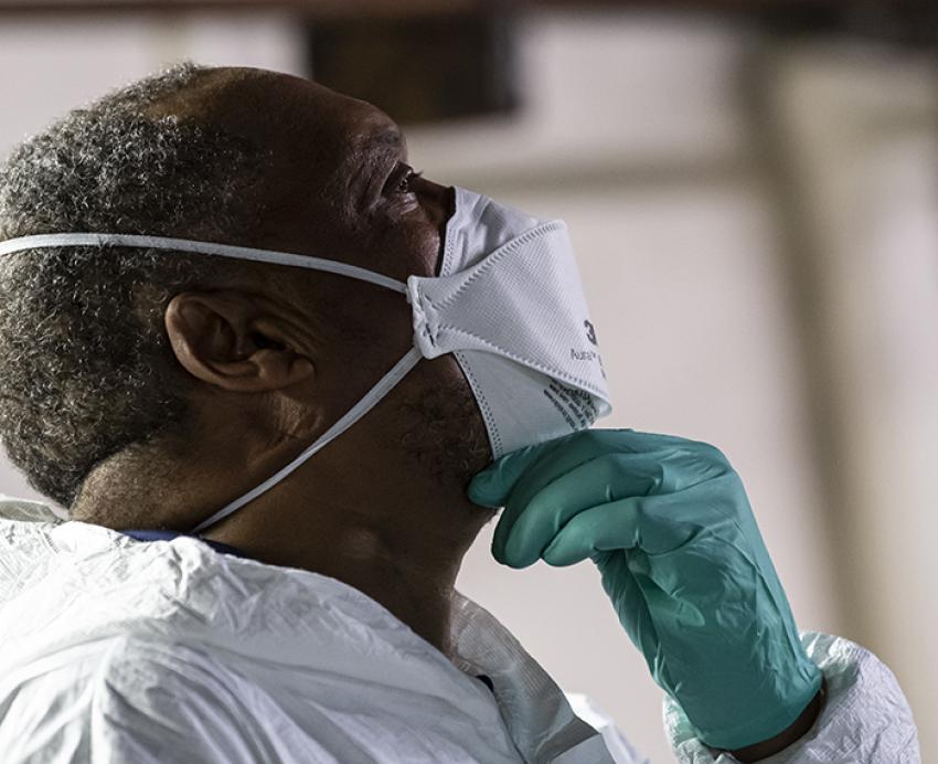 Man looking upward with rubber gloves and face mask