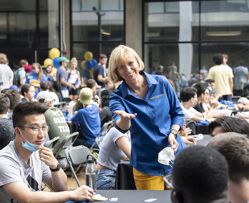 Students and faculty talking at table during orientation