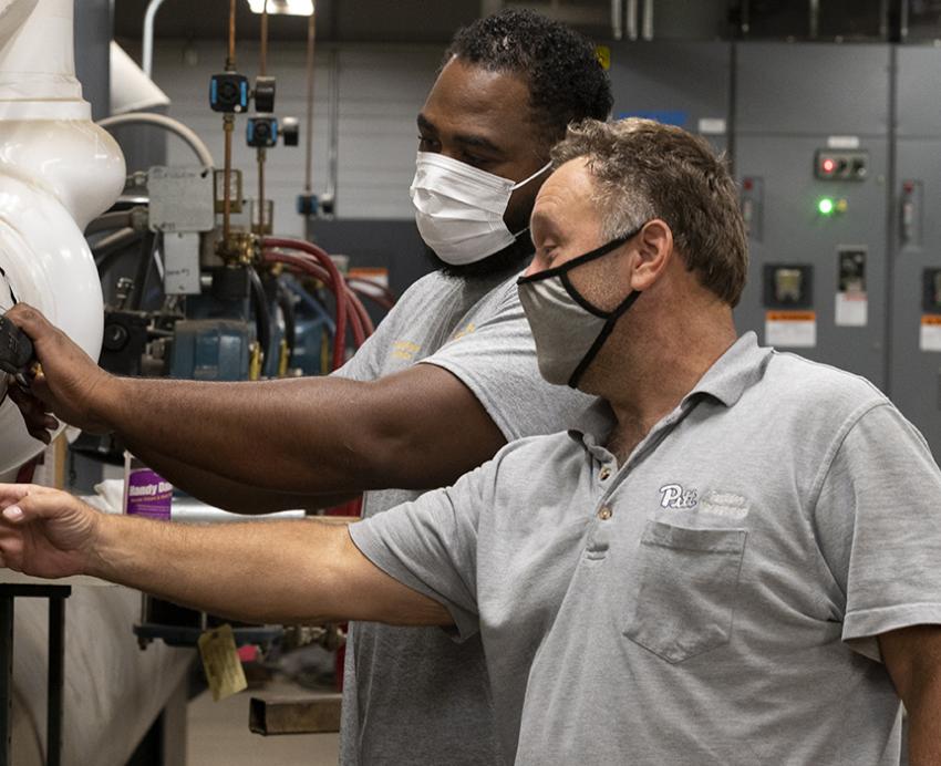 two engineers working together with masks