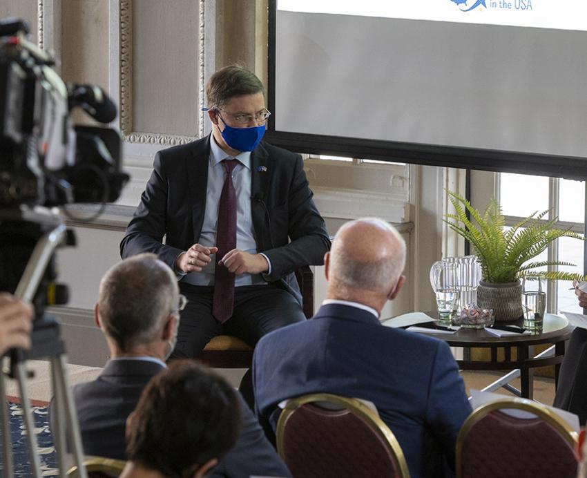Valdis Dombrovskis speaking with Erica Owen in front of crowd and camera crew