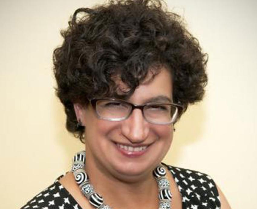 Ruth Mostern smiling with black and white shirt and necklace