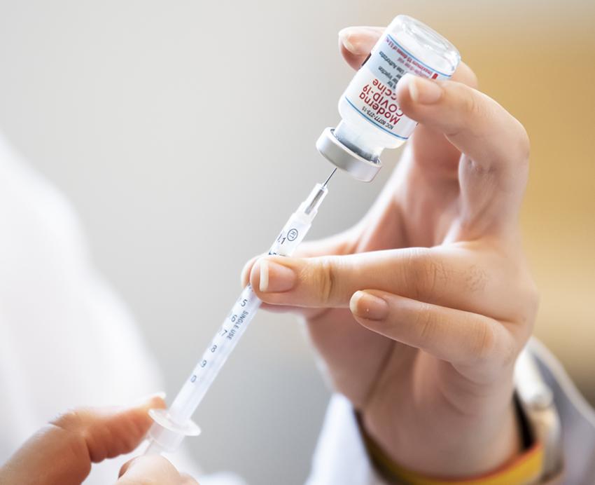 Health professional filling up a syringe 