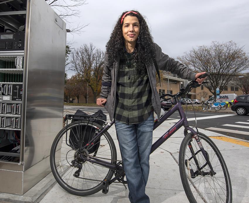 Mateus Martins standing with bicycle on the sidewalk.