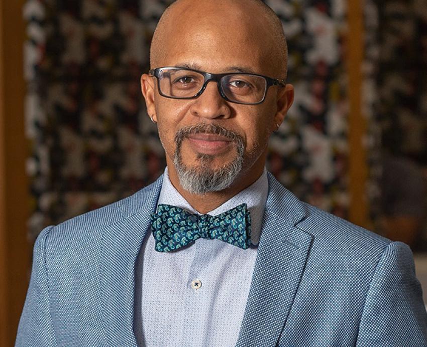 Gabby Yearwood wearing grey suit with blue bowtie